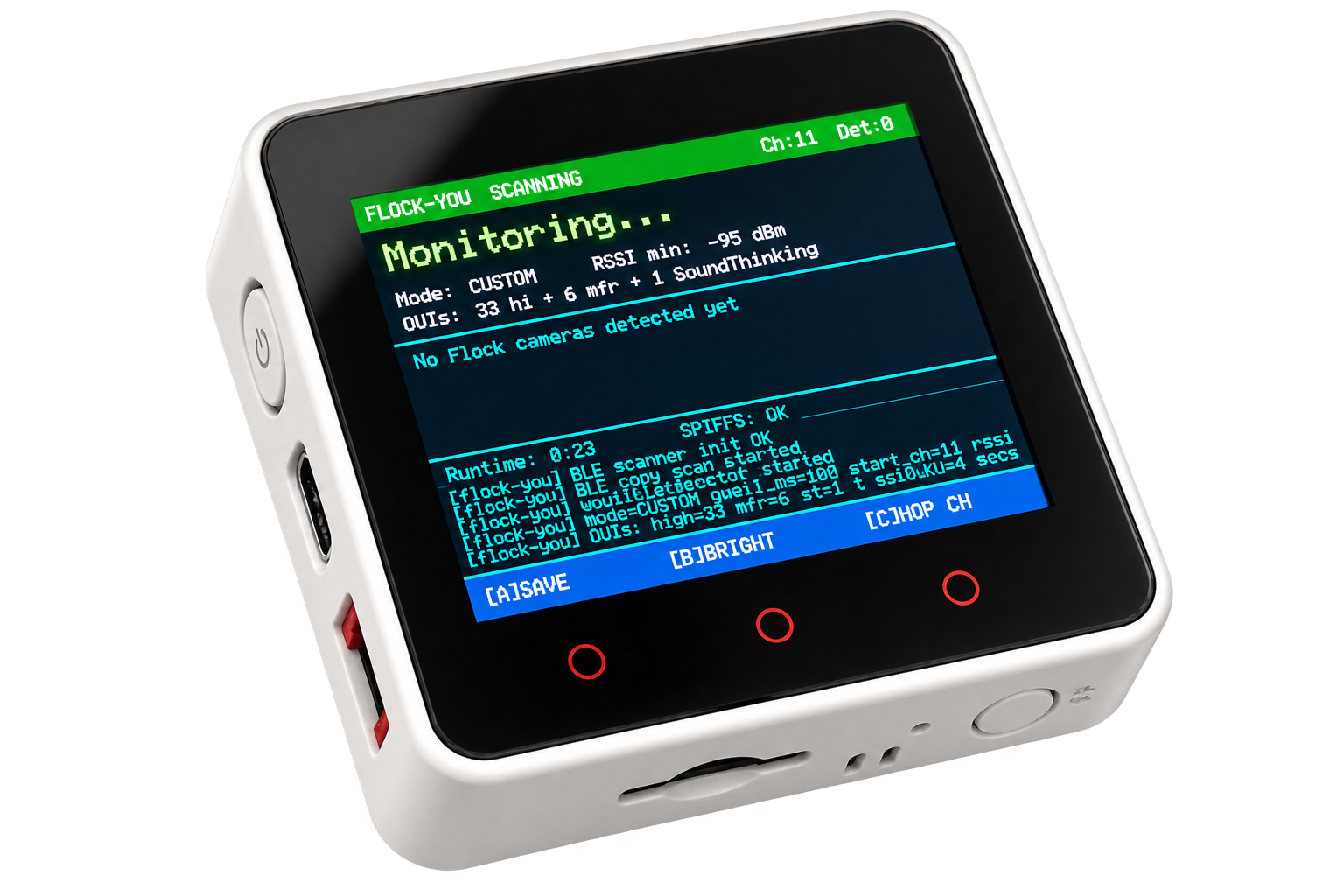 A white handheld electronic device with a black front face and a colorful LCD screen, shown on a plain white background. The screen displays a blue and green interface with text including 'FLOCK-YOU SCANNING' and 'Monitoring.
